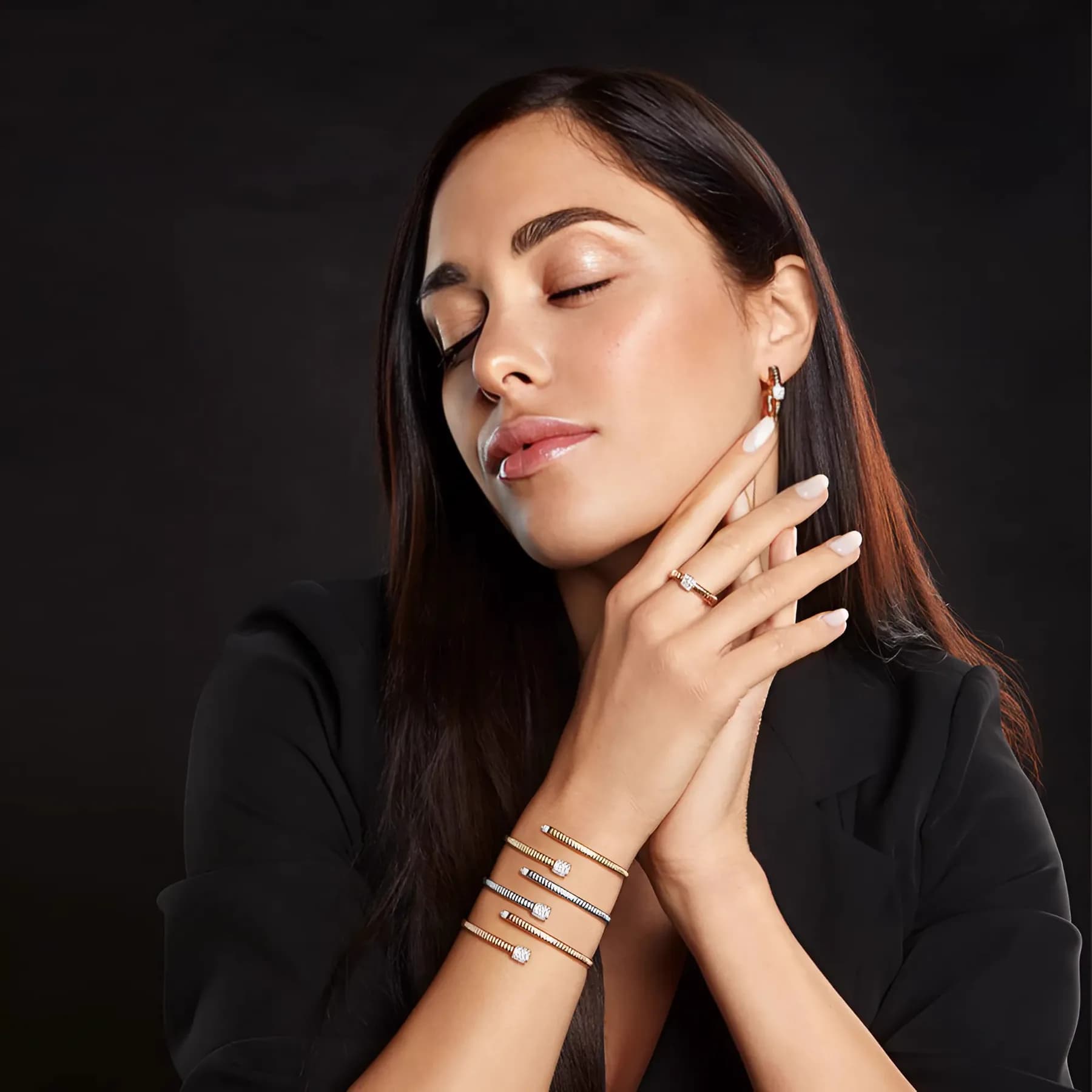 A stack of 7MARK gold and diamond bangles worn on the wrist